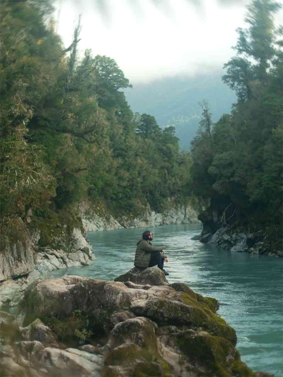 Man sitting on rock by lake
