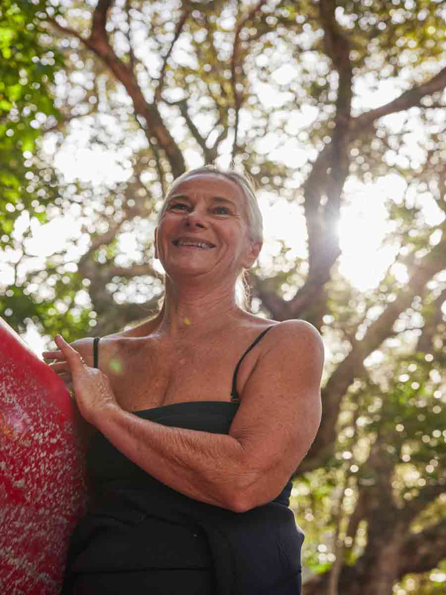 Woman with surfboard under arm